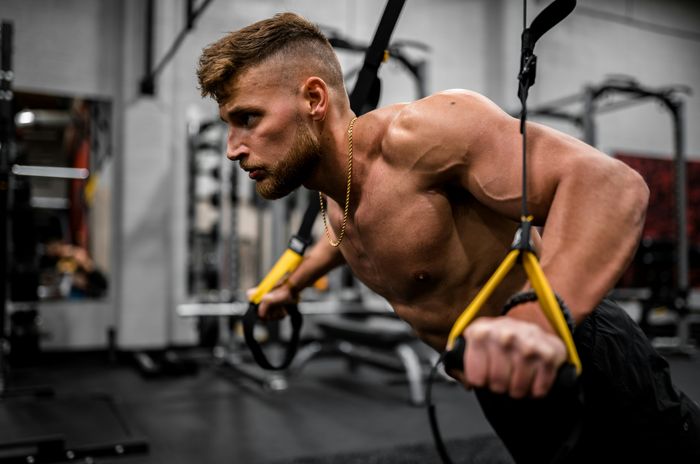 A man wearing silver jewelry working out
